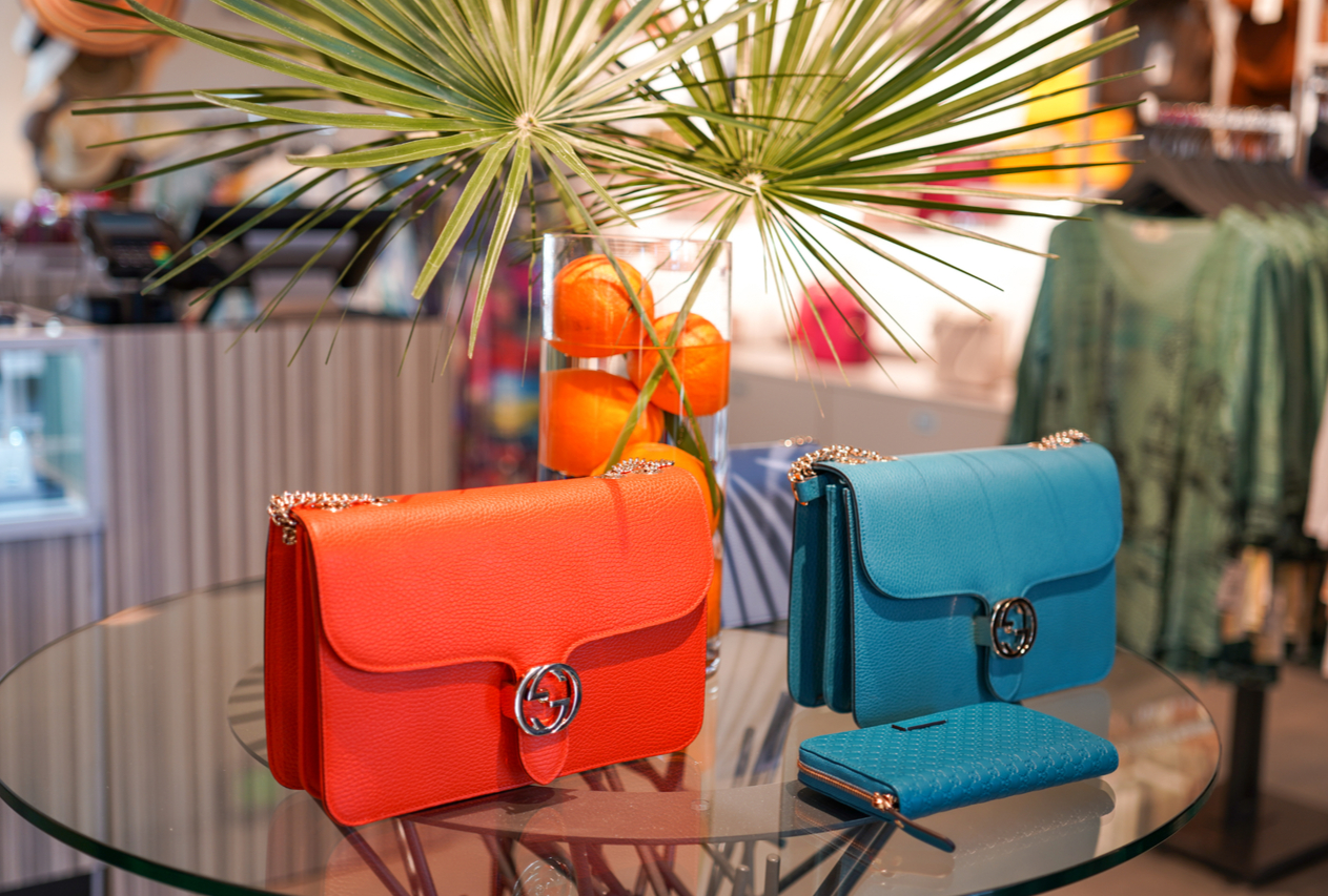 orange and teal designer purses on display table